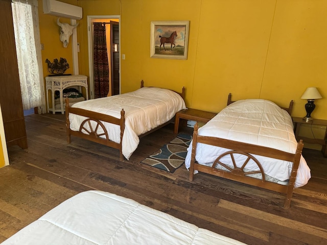 bedroom featuring an AC wall unit and dark hardwood / wood-style floors