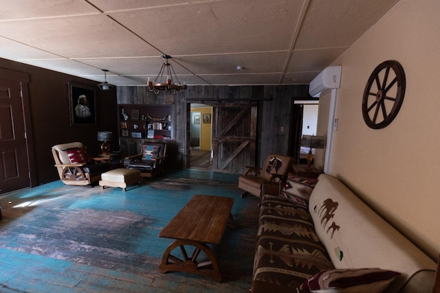 living room with hardwood / wood-style flooring, an inviting chandelier, wooden walls, a wall mounted air conditioner, and a barn door