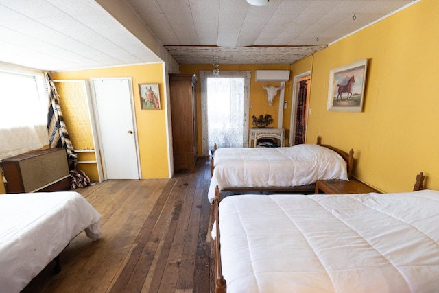 bedroom featuring a wall mounted AC and hardwood / wood-style floors