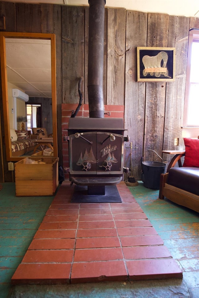 interior details with a wall mounted air conditioner, wooden walls, and a wood stove