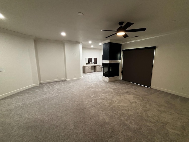 unfurnished living room featuring ornamental molding, ceiling fan, and carpet