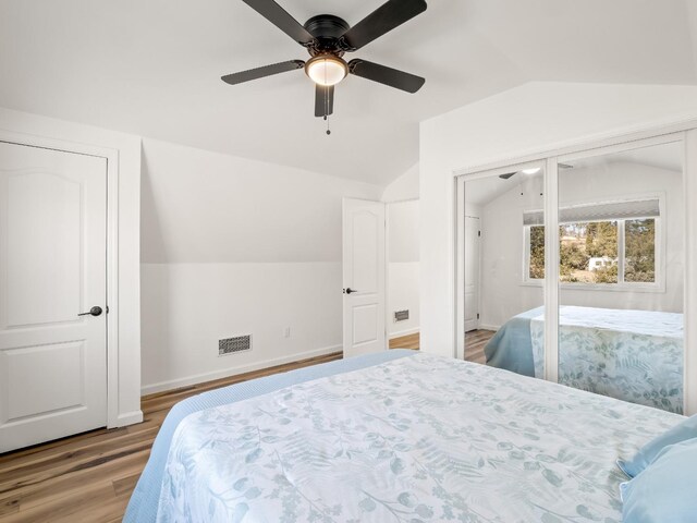 bedroom with ceiling fan, vaulted ceiling, and light wood-type flooring