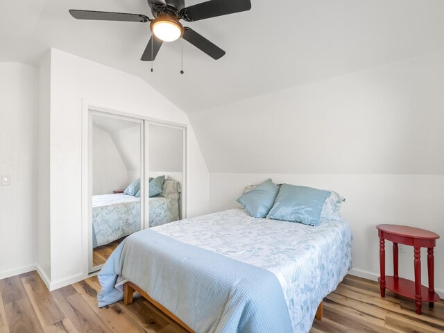 bedroom with lofted ceiling, light hardwood / wood-style floors, a closet, and ceiling fan