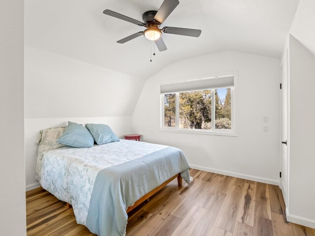 bedroom featuring hardwood / wood-style flooring, ceiling fan, and vaulted ceiling