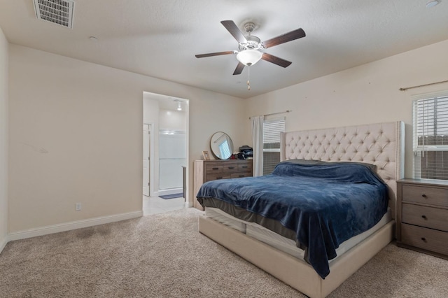 carpeted bedroom with ensuite bath and ceiling fan