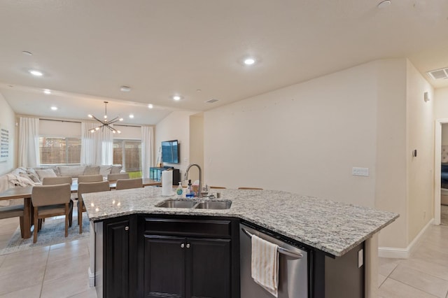 kitchen with an island with sink, sink, stainless steel dishwasher, and light stone counters