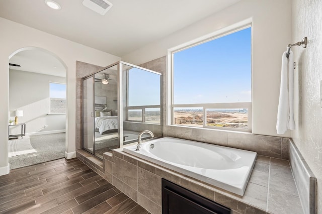 bathroom featuring a wealth of natural light, independent shower and bath, and ceiling fan