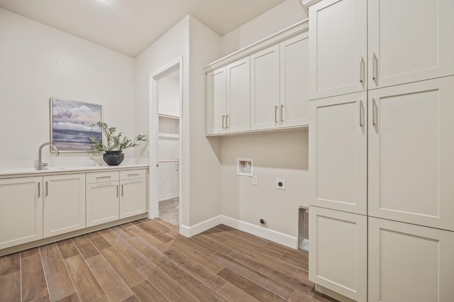 washroom featuring sink, cabinets, light hardwood / wood-style flooring, electric dryer hookup, and washer hookup