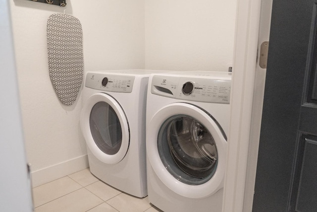 clothes washing area featuring independent washer and dryer and light tile patterned floors