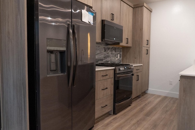 kitchen featuring tasteful backsplash, light wood-type flooring, and appliances with stainless steel finishes