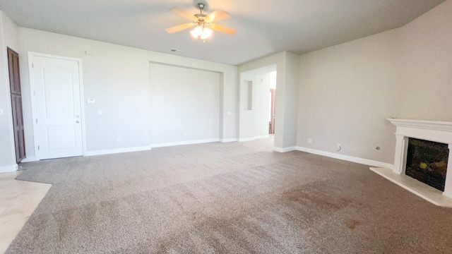 unfurnished living room featuring ceiling fan and carpet