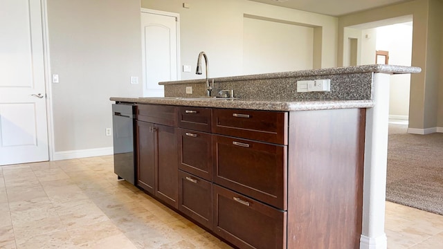 kitchen featuring stainless steel dishwasher, dark brown cabinets, sink, and a center island with sink