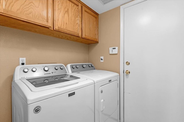 laundry room featuring cabinets and washing machine and dryer