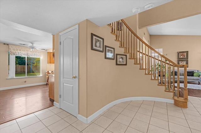 stairway featuring ceiling fan and tile patterned flooring