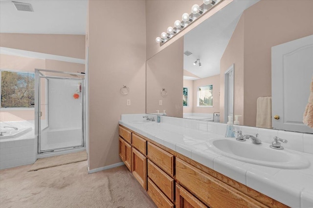 bathroom with vanity, vaulted ceiling, and independent shower and bath