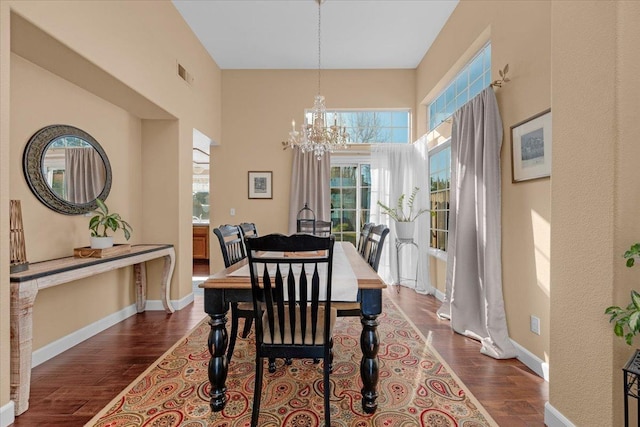 dining space featuring dark wood-type flooring and a chandelier