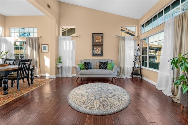 sitting room with dark hardwood / wood-style floors and high vaulted ceiling