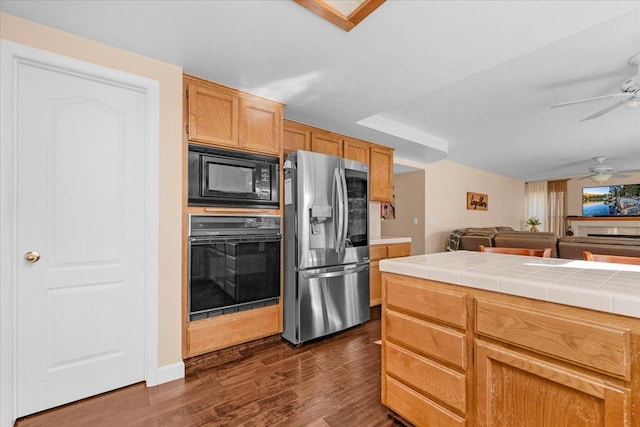 kitchen with ceiling fan, tile countertops, dark hardwood / wood-style flooring, and black appliances