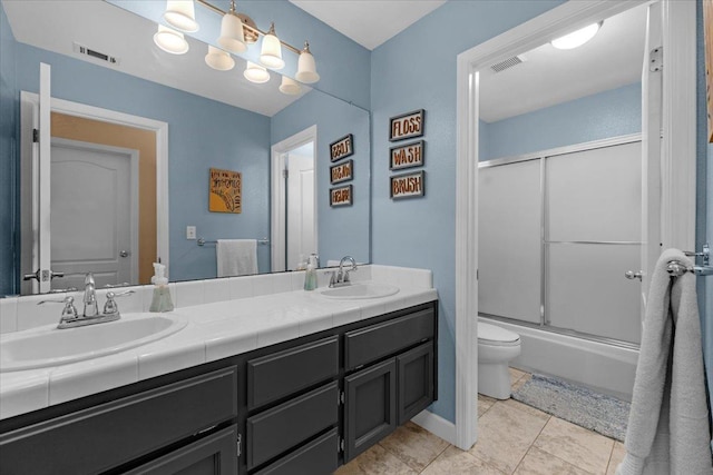 full bathroom featuring tile patterned flooring, enclosed tub / shower combo, vanity, and toilet