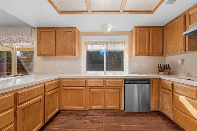 kitchen featuring sink, dark wood-type flooring, dishwasher, backsplash, and tile countertops