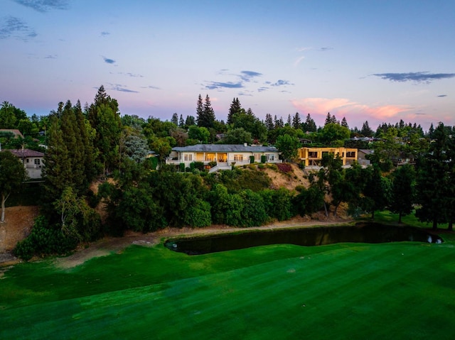 yard at dusk featuring a water view