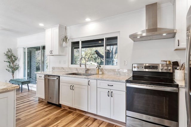 kitchen with stainless steel appliances, white cabinetry, light stone counters, and wall chimney exhaust hood