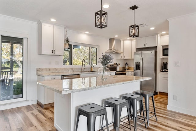 kitchen with white cabinets, sink, wall chimney exhaust hood, and appliances with stainless steel finishes