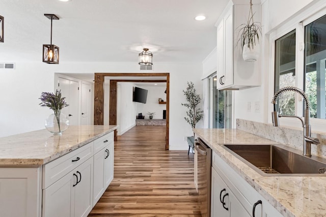 kitchen with dishwasher, sink, and white cabinets