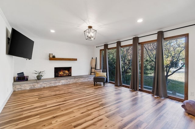 interior space with a notable chandelier, wood-type flooring, a fireplace, and a wealth of natural light