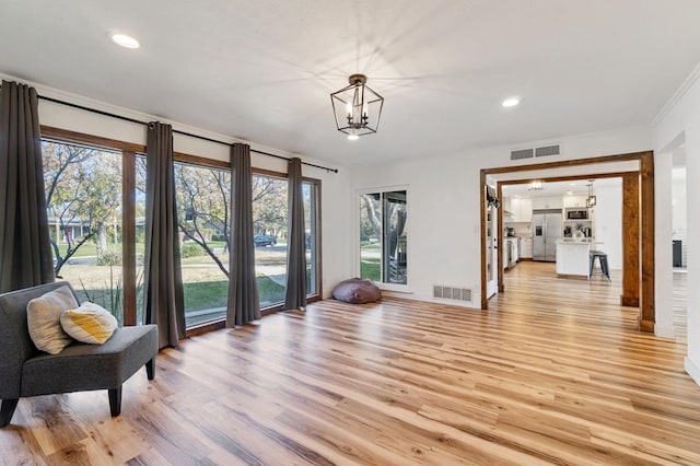 living area featuring a notable chandelier and light wood-type flooring