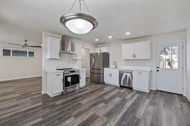 kitchen with appliances with stainless steel finishes, sink, white cabinets, and wall chimney exhaust hood