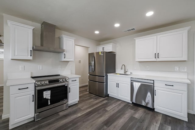 kitchen with appliances with stainless steel finishes, sink, white cabinets, dark hardwood / wood-style flooring, and wall chimney exhaust hood