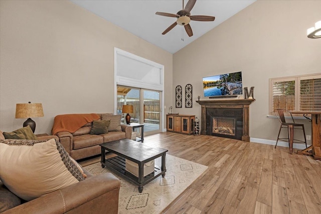 living room with light hardwood / wood-style flooring, high vaulted ceiling, and ceiling fan