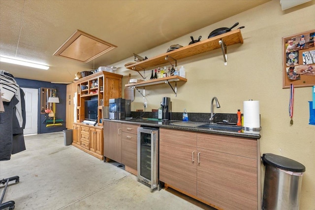 kitchen featuring sink, beverage cooler, and dark stone counters