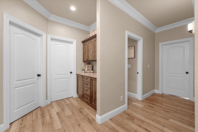 hallway with ornamental molding and light hardwood / wood-style flooring