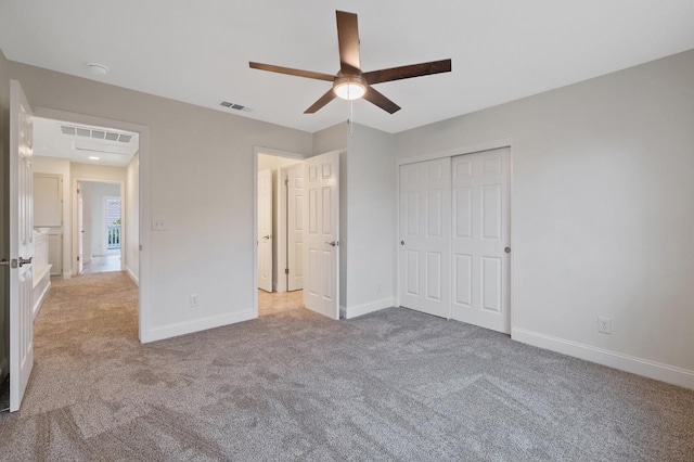 unfurnished bedroom featuring light carpet, ceiling fan, and a closet