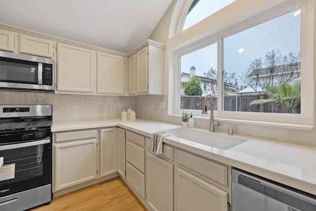 968 E Muncie, Fresno, CA 93720 - kitchen featuring appliances with stainless steel finishes, a sink, light countertops, tasteful backsplash, and light wood-type flooring