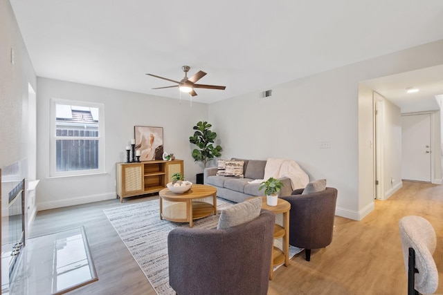 living room with ceiling fan and light hardwood / wood-style flooring