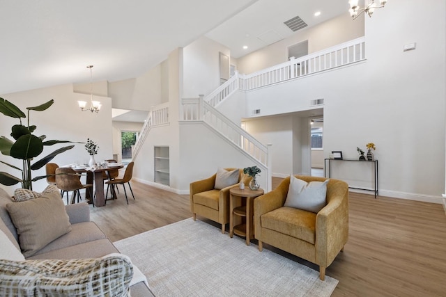 968 E Muncie, Fresno, CA 93720 - living room featuring stairs, wood finished floors, high vaulted ceiling, baseboards, and a notable chandelier