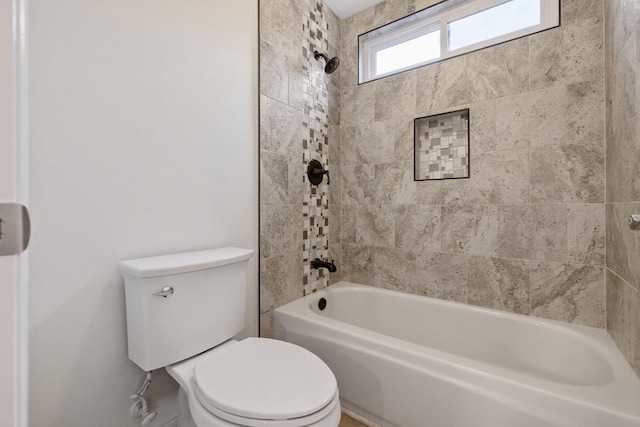 bathroom featuring tiled shower / bath and toilet