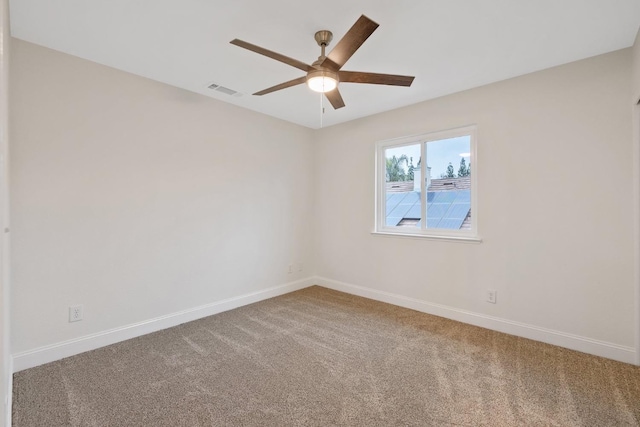 carpeted spare room featuring ceiling fan