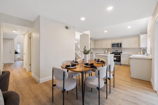 dining space featuring sink and light wood-type flooring