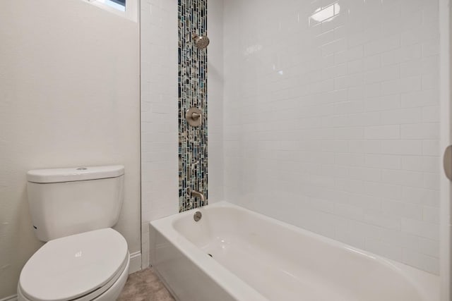 bathroom featuring tiled shower / bath and toilet