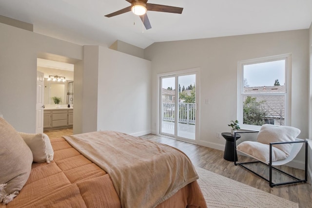 bedroom featuring lofted ceiling, ensuite bathroom, light wood-type flooring, and access to outside