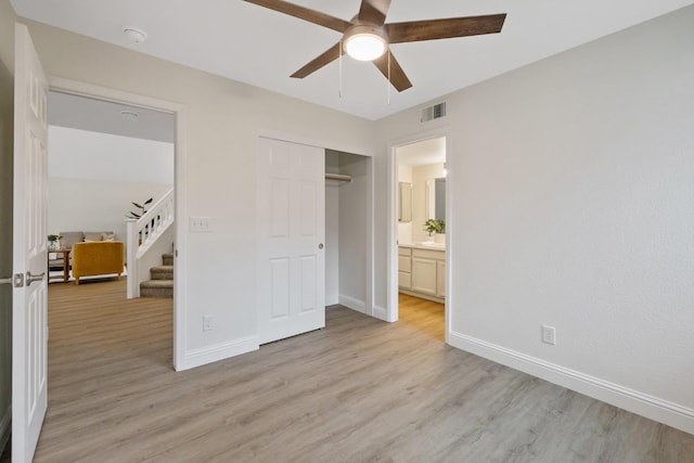 unfurnished bedroom with ceiling fan, a closet, and light wood-type flooring