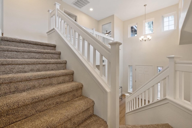 staircase with a chandelier