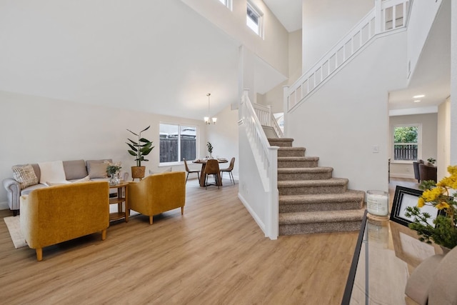 interior space featuring an inviting chandelier, high vaulted ceiling, and light hardwood / wood-style flooring