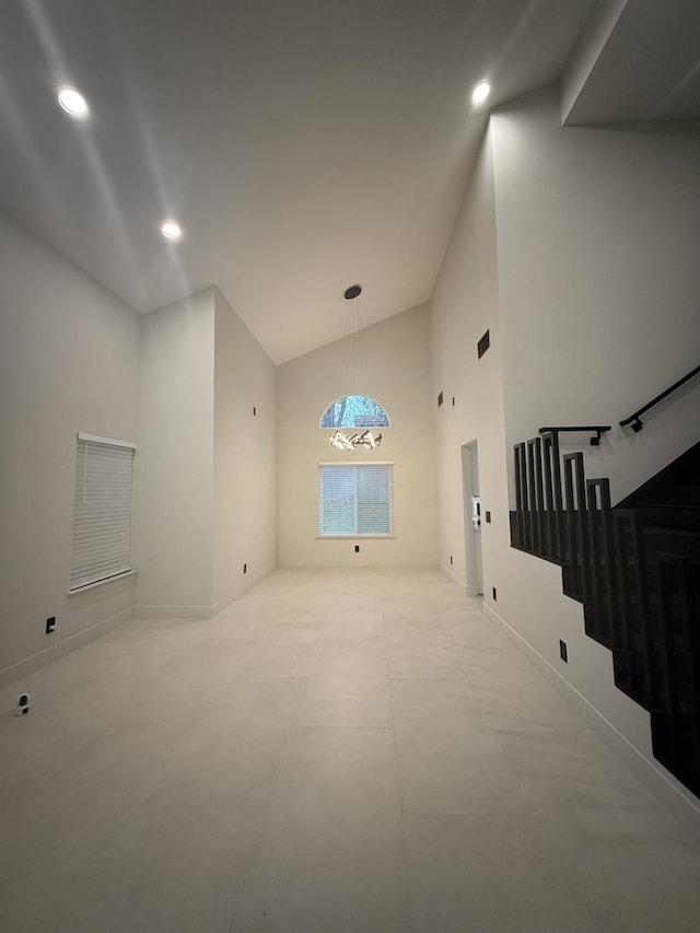 unfurnished living room featuring high vaulted ceiling