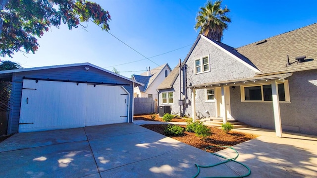 438 E Clinton Ave, Fresno, CA 93704 - view of side of property with stucco siding, an outdoor structure, a garage, and central air condition unit