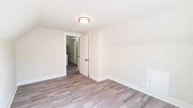 additional living space featuring lofted ceiling and light hardwood / wood-style flooring